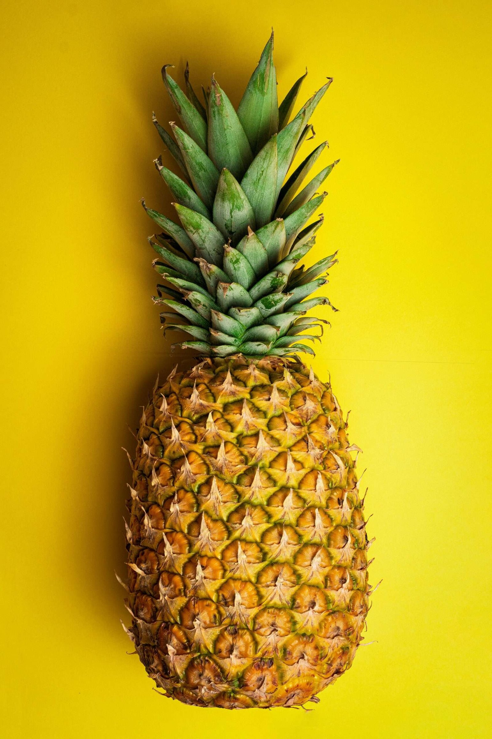Home pineapple fruit on yellow surface