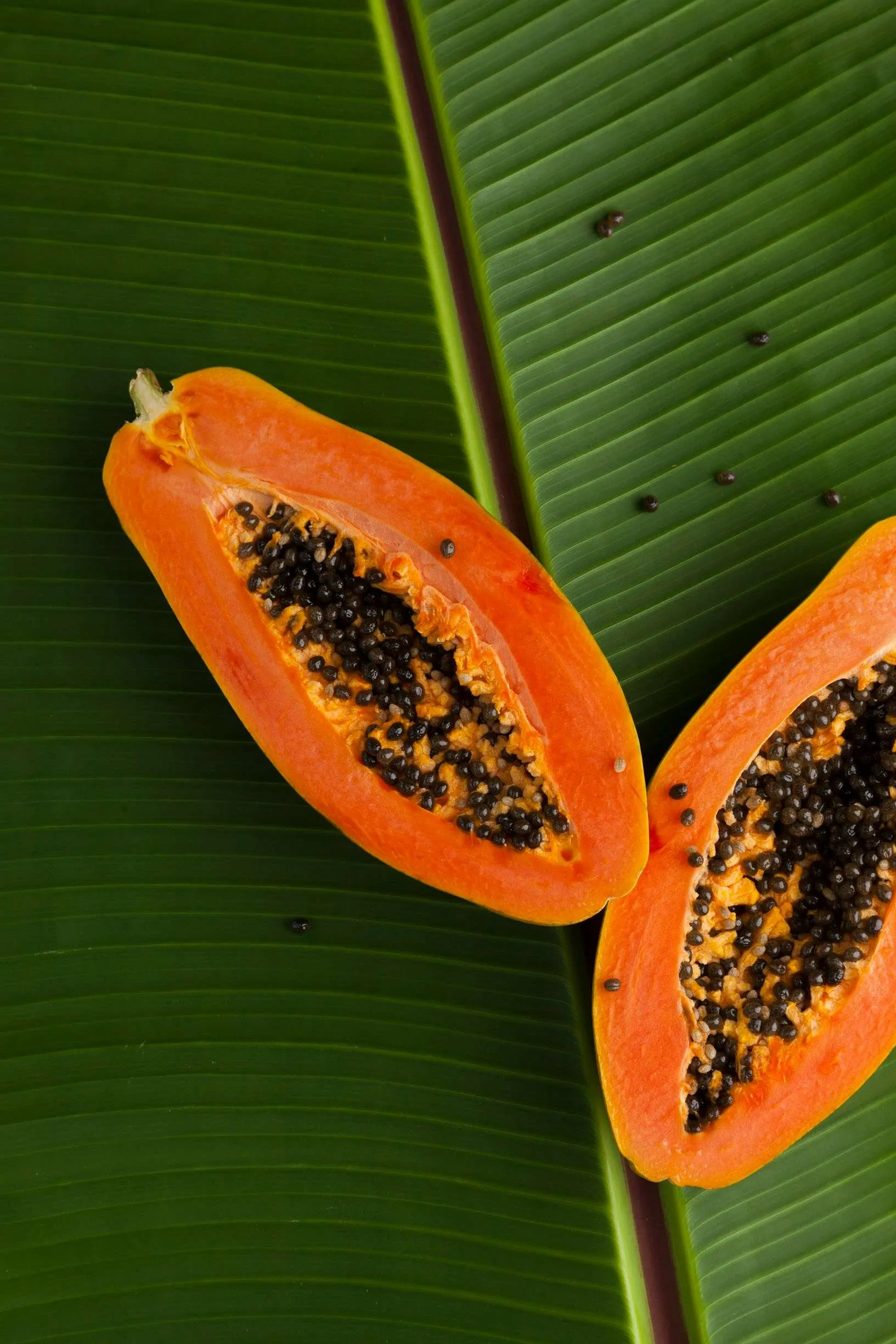 Home sliced papaya on green banana leaf